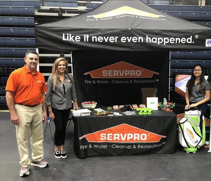 3 people in front of servpro tent 